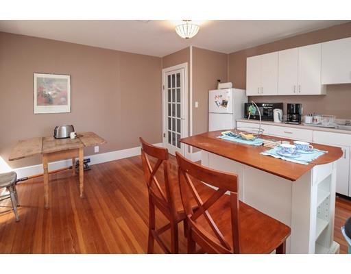 929 Beacon Street Newton, MA 02459 - Photo 32 of 36 a open kitchen with stainless steel appliances granite countertop a stove a refrigerator a sink dishwasher and white cabinets with wooden floor