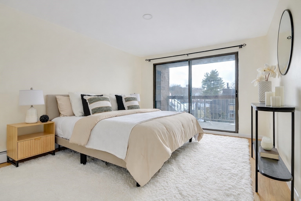 321 Harvard Street, Unit 307 Cambridge, MA 02139 - Photo 11 of 26 a bedroom with a bed and a large window
