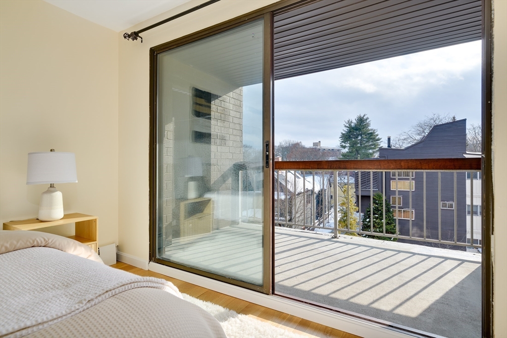 321 Harvard Street, Unit 307 Cambridge, MA 02139 - Photo 12 of 26 a bedroom with a bed and a large window with outer view