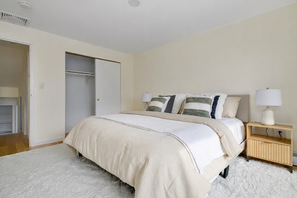 321 Harvard Street, Unit 307 Cambridge, MA 02139 - Photo 13 of 26 a bedroom with bed and a night stand