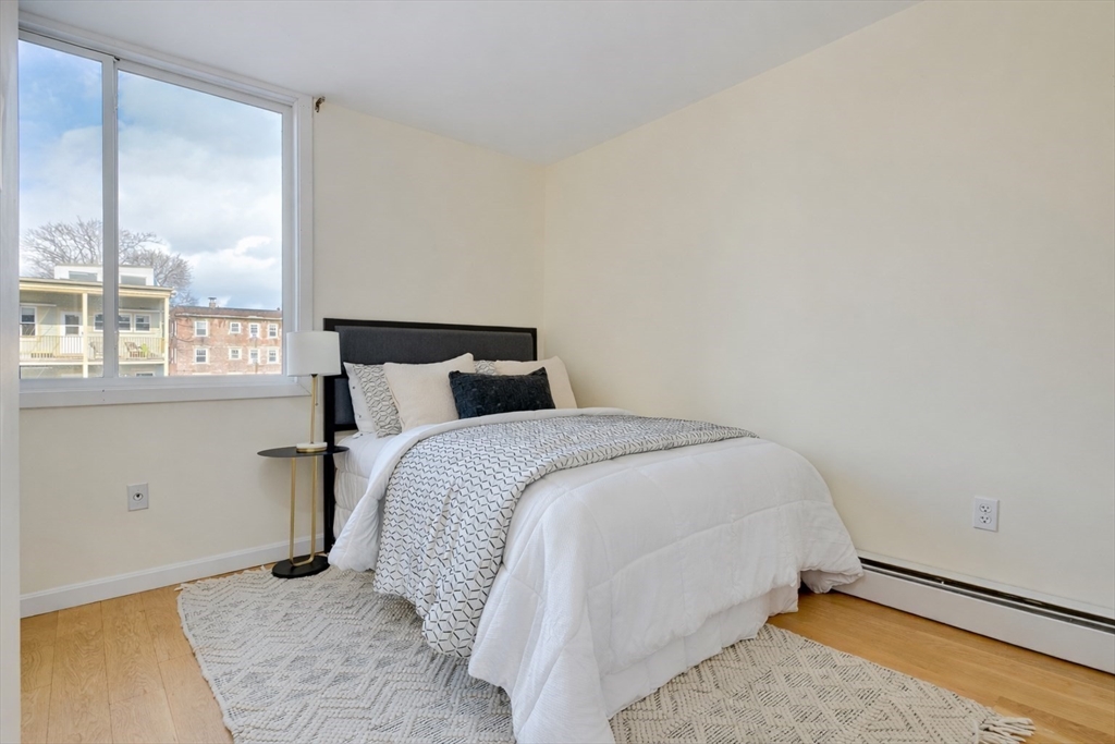 321 Harvard Street, Unit 307 Cambridge, MA 02139 - Photo 16 of 26 a bedroom with a bed and window