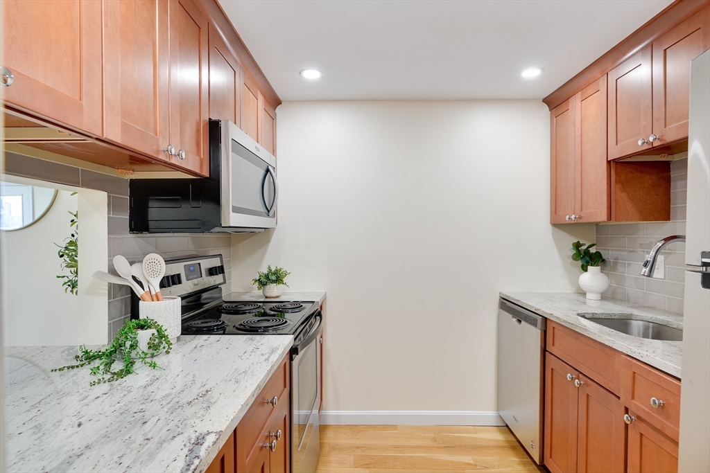 321 Harvard Street, Unit 307 Cambridge, MA 02139 - Photo 7 of 26 a kitchen with stainless steel appliances granite countertop a sink stove and microwave