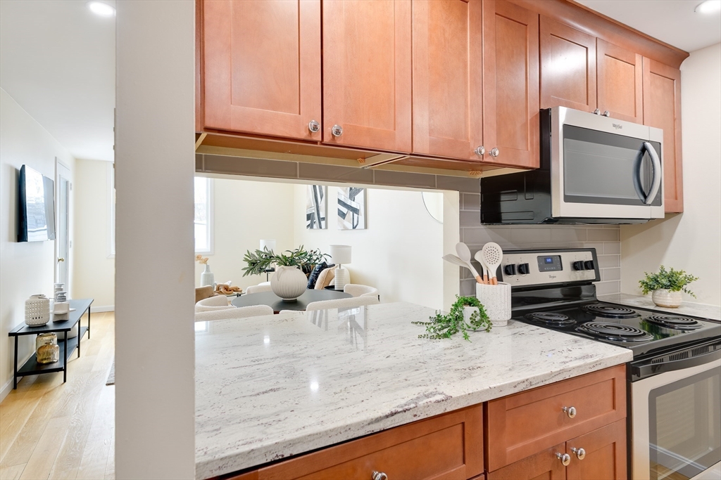 321 Harvard Street, Unit 307 Cambridge, MA 02139 - Photo 8 of 26 a kitchen with stainless steel appliances granite countertop a stove a sink and a microwave