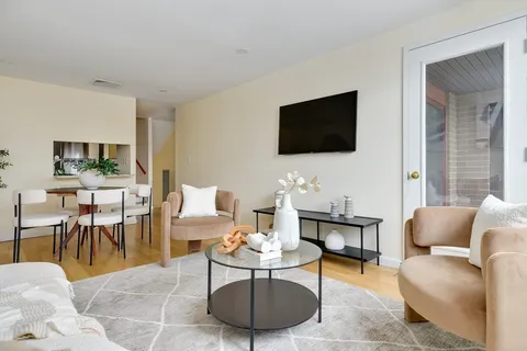 a living room with furniture a flat screen tv and a large window