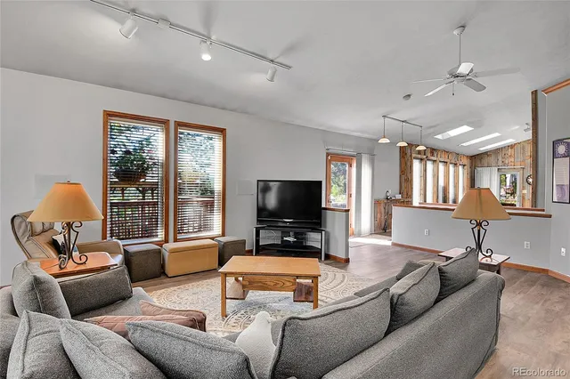 a living room with furniture a flat screen tv and a window
