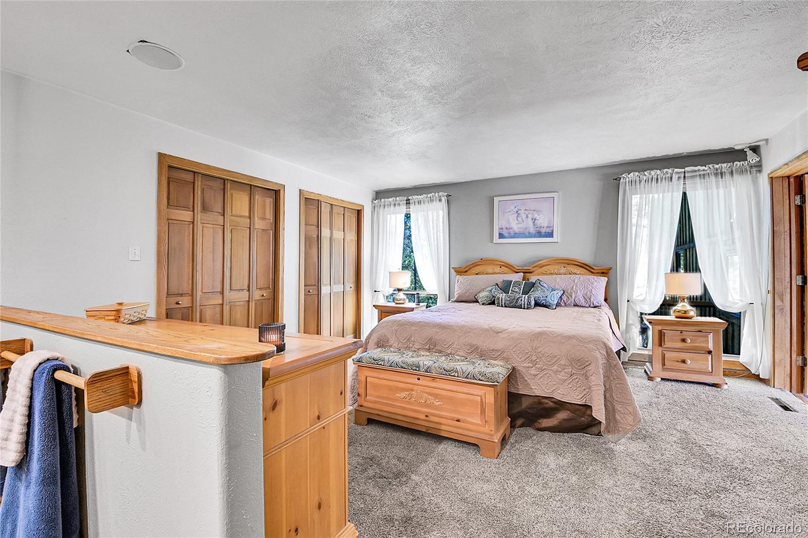 13082 South Wamblee Valley Road Conifer, CO 80433 - Photo 37 of 46 a bedroom with a bed and a large mirror on the dresser