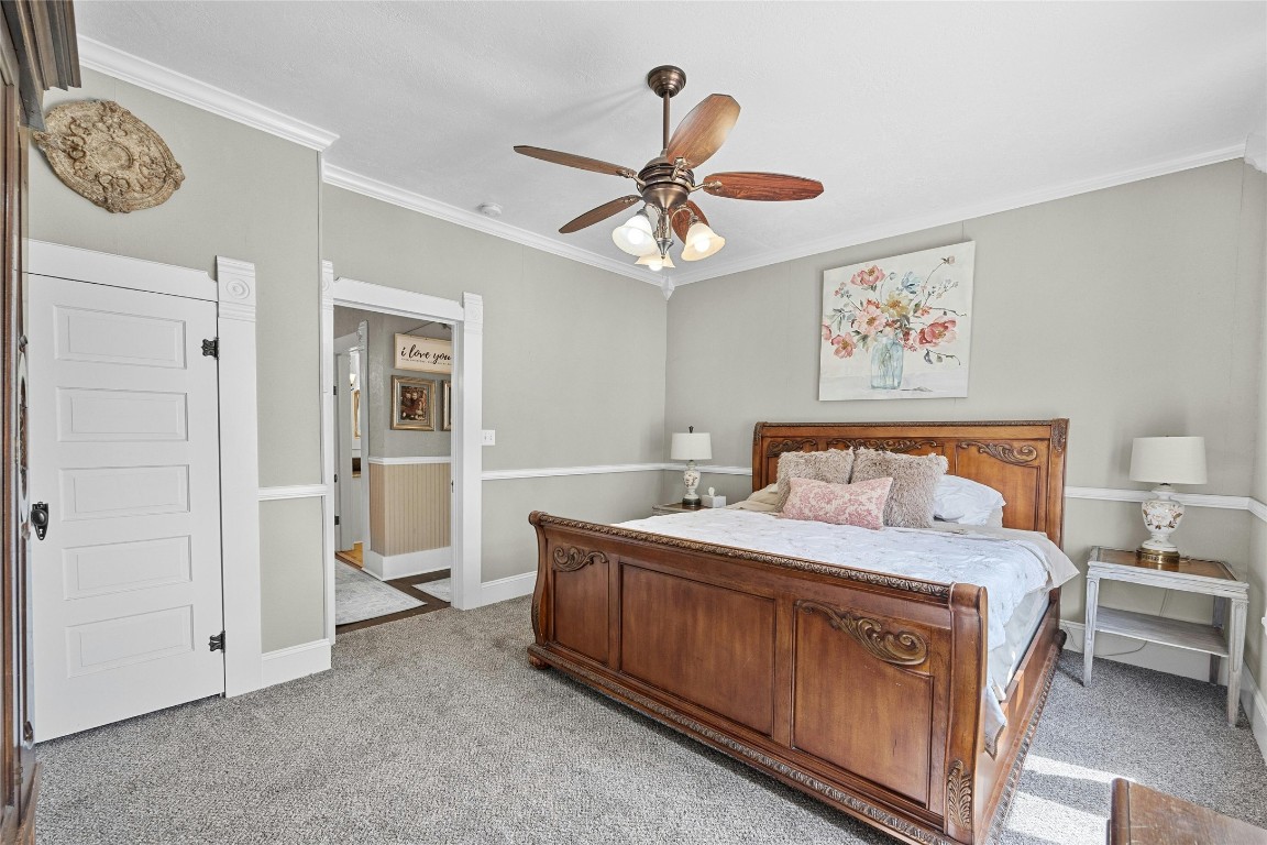 622 West 7th Street Taylor, TX 76574 - Photo 18 of 35 a bedroom with a bed and a chandelier