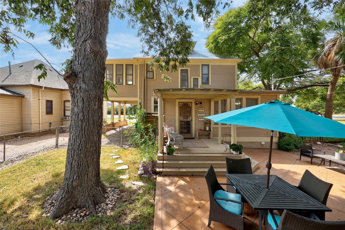 622 West 7th Street Taylor, TX 76574 - Photo 27 of 35 a patio with a table and chairs under an umbrella