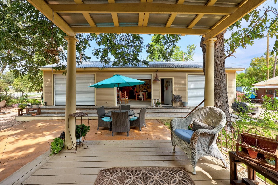622 West 7th Street Taylor, TX 76574 - Photo 30 of 35 a view of a patio with table and chairs under an umbrella with a barbeque