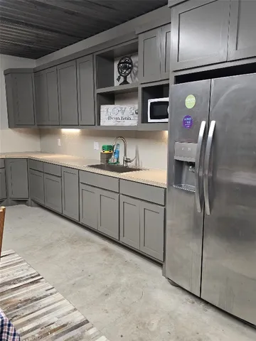 a kitchen with stainless steel appliances granite countertop a refrigerator a sink and wooden cabinets