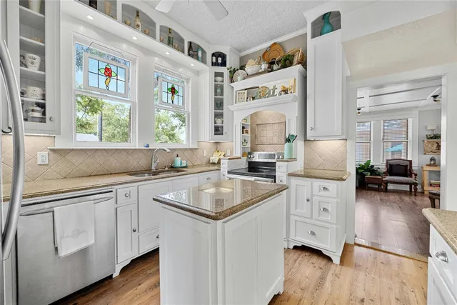 a kitchen with a sink cabinets and wooden floor