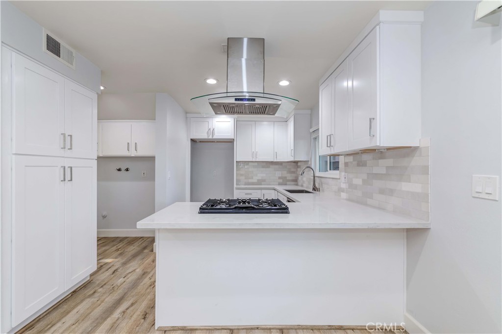 8243 Inverness Buena Park, CA 90621 - Photo 1 of 1 a kitchen with kitchen island granite countertop a sink cabinets and stainless steel appliances