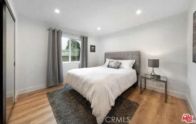 a bedroom with a bed and wooden floor