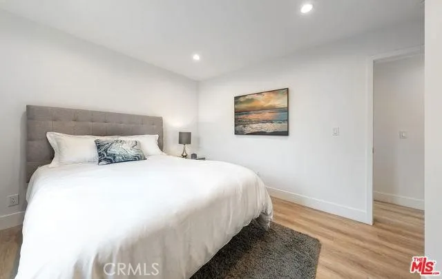 a bedroom with bed and wooden floor