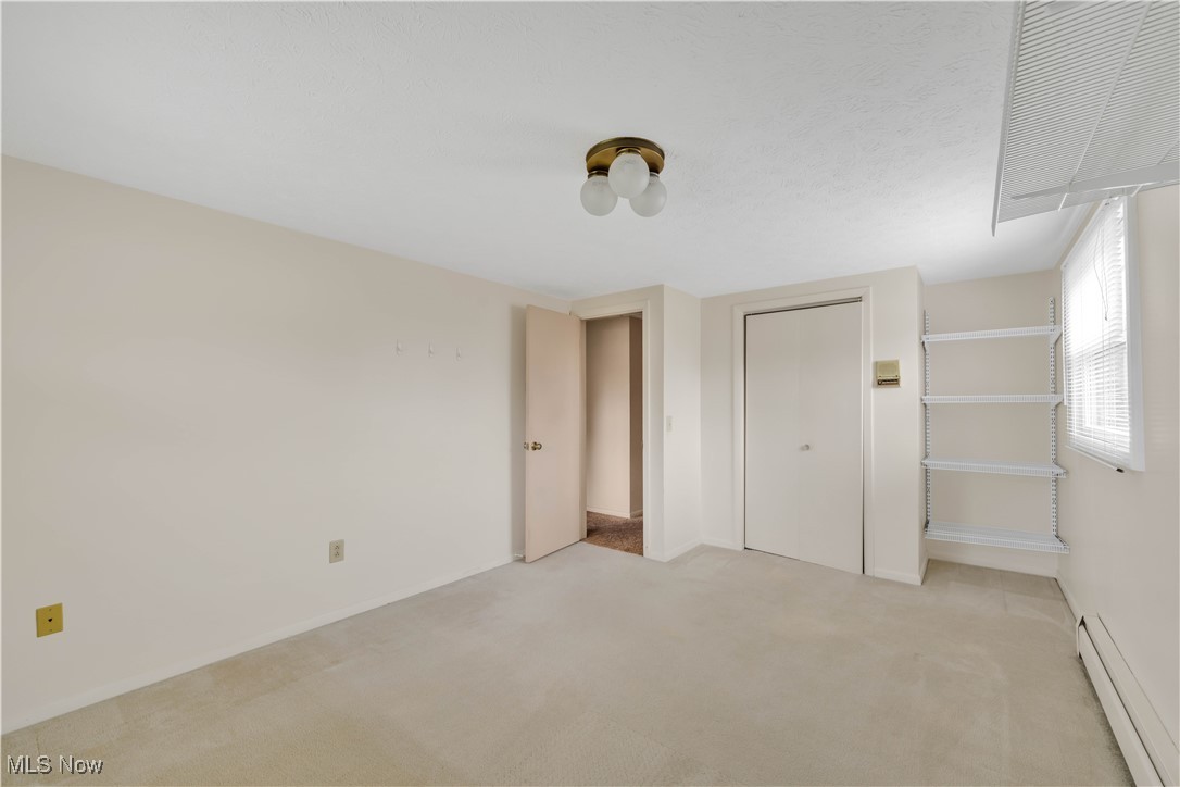506 Logan Road Mansfield, OH 44907 - Photo 26 of 46 Unfurnished bedroom featuring a baseboard radiator, light colored carpet, and a closet