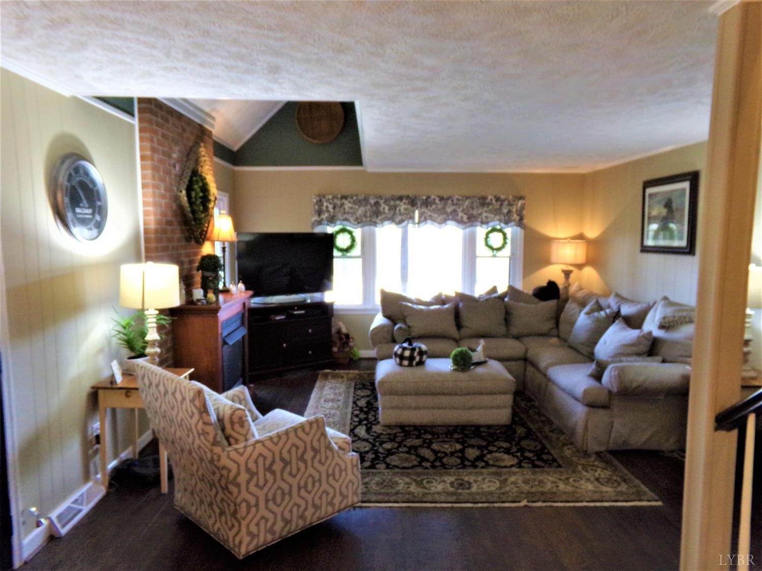 671 Countyline Road Keysville, VA 23947 - Photo 14 of 38 a living room with furniture a flat screen tv and a fireplace