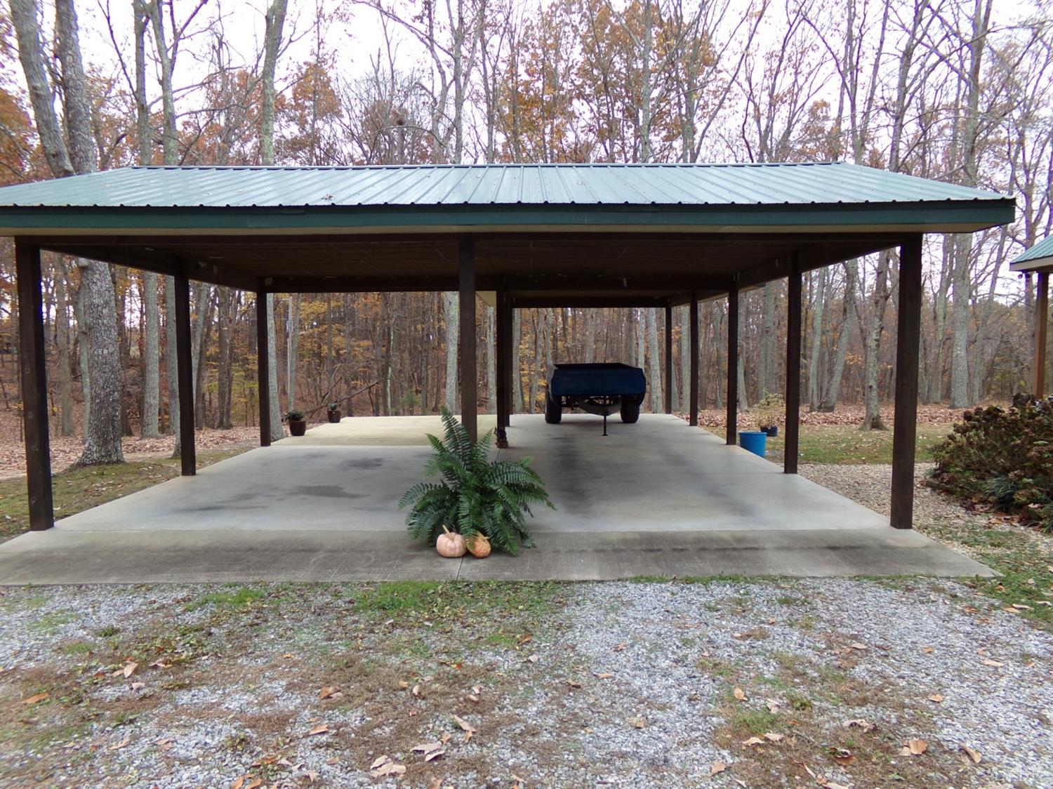 671 Countyline Road Keysville, VA 23947 - Photo 33 of 38 a view of a patio with table and chairs under an umbrella with large trees