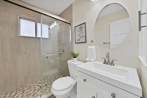 a bathroom with a sink a toilet and shower
