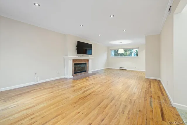 a view of empty room with wooden floor and fireplace