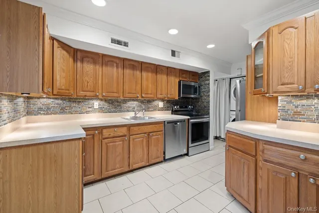 a kitchen with kitchen island granite countertop a sink stainless steel appliances and cabinets