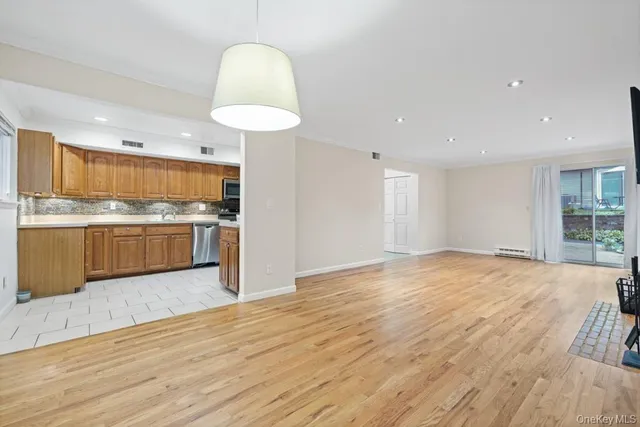a view of empty room with wooden floor and fireplace