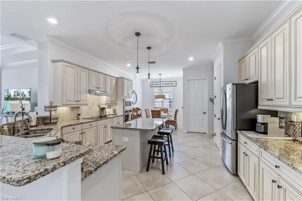 a kitchen with granite countertop cabinets a sink a counter space stainless steel appliances and cabinets