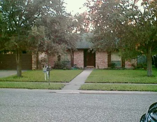 a front view of a house with a yard and trees