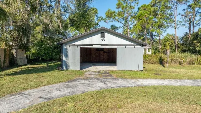 a view of a house with a yard and large trees