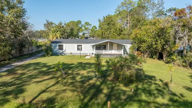 a white house sitting in middle of a garden