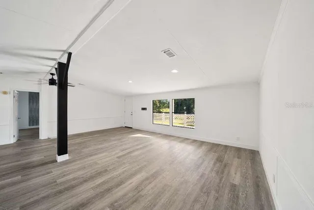 a view of a room with wooden floor and a window