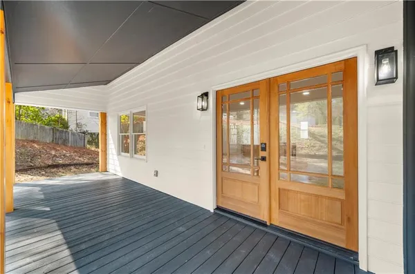 a view of an empty room with wooden floor and windows