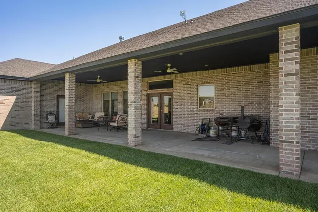 a house is sitting in middle of the green field