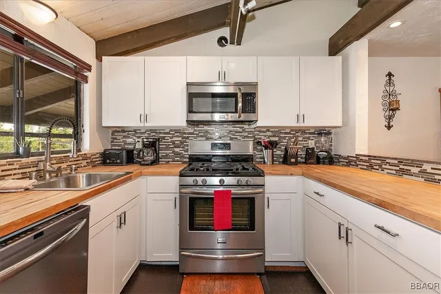 a kitchen with stainless steel appliances granite countertop a stove and a sink