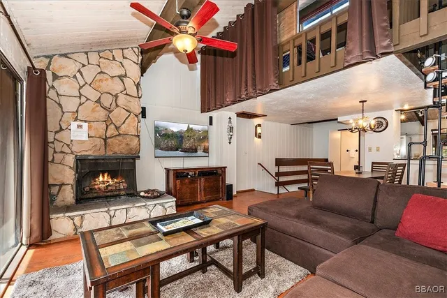 a living room with furniture a fireplace and a flat screen tv
