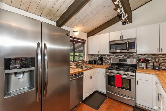 a kitchen with granite countertop a refrigerator stove and microwave