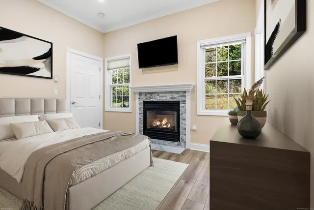 a living room with furniture a flat screen tv and a fireplace