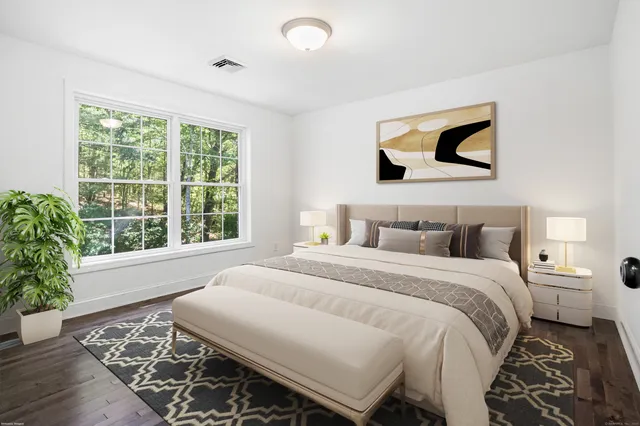 a bedroom with a bed and a painting on the wall