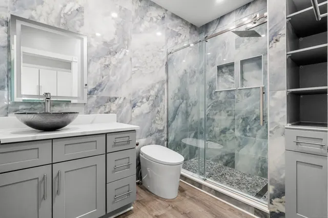 a bathroom with a sink a toilet and shower