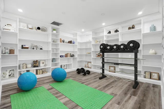 a living room with furniture a rug and gym equipment