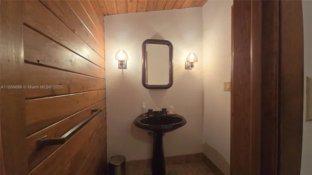 a bathroom with a sink a light fixture and a mirror