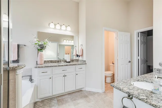 a spacious bathroom with a granite countertop sink and a mirror