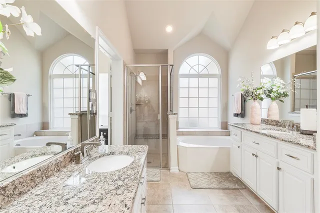 a spacious bathroom with a granite countertop tub mirror and a shower