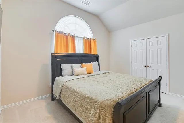 a bed sitting in a bedroom next to a window