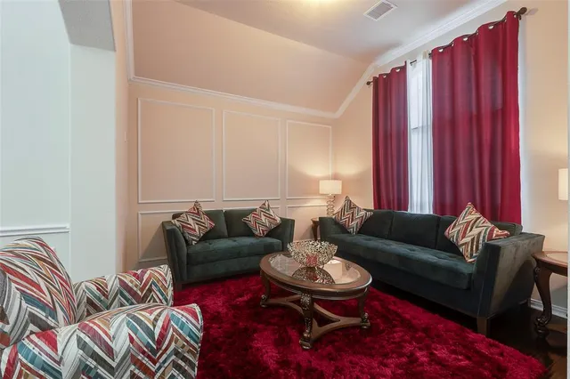 a living room with furniture and a red chair
