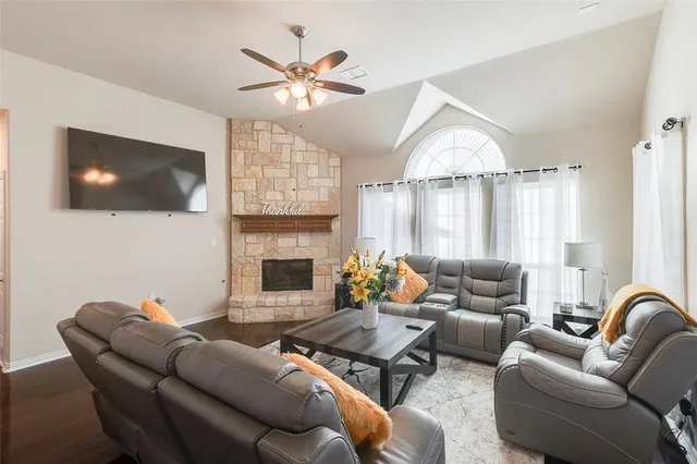 a living room with furniture a flat screen tv and a fireplace