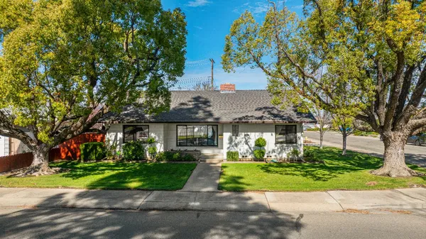 a front view of a house with a yard and potted plants