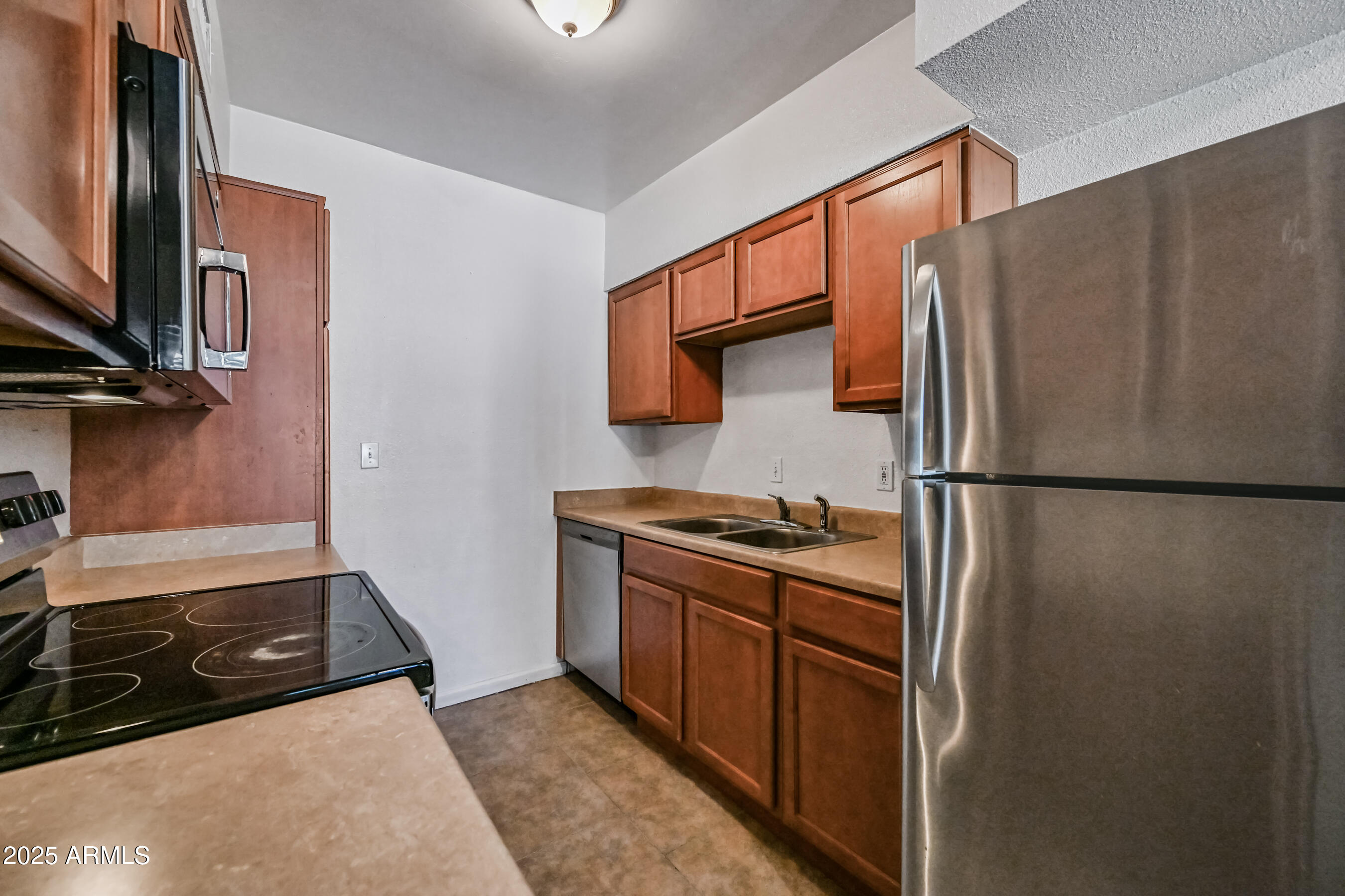 1518 West Colter Street, Unit 29 Phoenix, AZ 85015 - Photo 9 of 15 a kitchen with stainless steel appliances granite countertop a refrigerator a stove and a sink