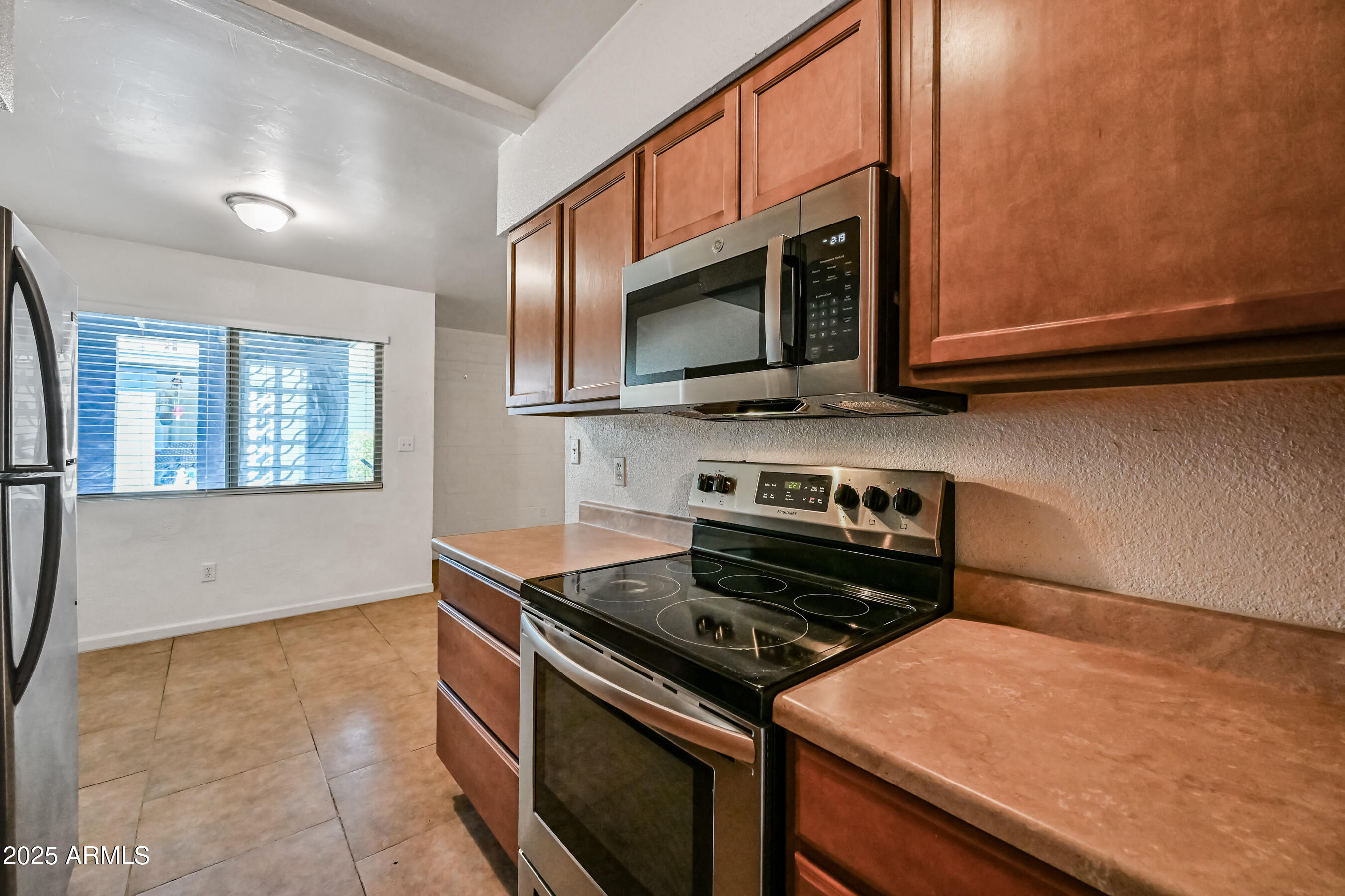 1518 West Colter Street, Unit 29 Phoenix, AZ 85015 - Photo 10 of 15 a kitchen with a stove and a microwave