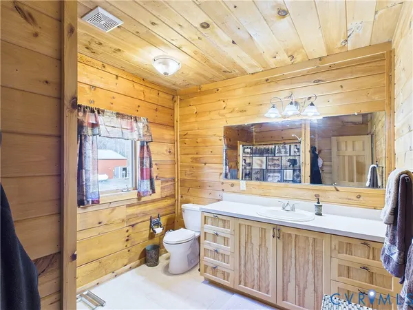 a bathroom with a sink a large mirror and a bathtub next to a window