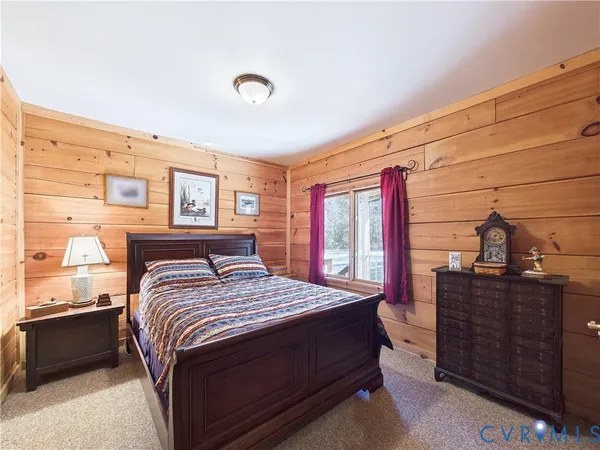 a bedroom with a bed and dresser with mirror